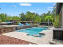 Beautiful backyard pool and waterfall feature with lush landscaping, perfect for relaxation at 26221 Pheasant Run, Wesley Chapel, FL 33544