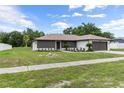 Single story home showcasing a well-maintained lawn and a neatly landscaped garden at 3498 Plaza Ave, Spring Hill, FL 34608