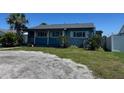 A quaint blue single-story home with lush front lawn and mature trees at 4027 31St N Ave, St Petersburg, FL 33713