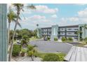 View of the building's exterior with parking lot and landscaping on a sunny day at 5640 Ferguson Ct # 2203, New Port Richey, FL 34652
