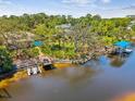 Beautiful backyard featuring a lovely deck, blue swimming pool, boat dock, and plenty of foliage at 5903 Cachette De Riviera Ct, New Port Richey, FL 34655