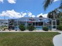 Enjoy outdoor living with this screened-in pool area, featuring lounge chairs and beautiful landscaping for ultimate relaxation at 6737 Clark St, Hudson, FL 34667