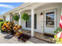Close-up of the front porch with decorative plants and tiled flooring at 6930 El Camino Paloma St, Port Richey, FL 34668