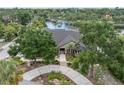 Stunning waterfront home featuring lush landscaping, circular driveway, and tranquil views at 6936 River Rd, New Port Richey, FL 34652
