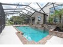 Inviting screened-in pool area with brick accents and lush landscaping, a relaxing outdoor retreat at 6936 River Rd, New Port Richey, FL 34652