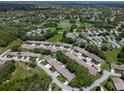 Expansive aerial shot of a residential community with lush greenery, winding streets, and a tranquil pond at 7445 Nature Walk Dr, Spring Hill, FL 34606