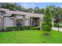 Well-manicured lawn with decorative shrubs and a charming bench on the front porch of the home at 7445 Nature Walk Dr, Spring Hill, FL 34606