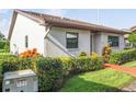 Side view of a well-kept single-story home surrounded by lush green hedges and manicured landscaping at 7715 Radcliffe Cir, Port Richey, FL 34668