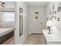 Bright hallway featuring neutral flooring, a decorative mirror, and a view into the adjacent bedroom at 7715 Radcliffe Cir, Port Richey, FL 34668