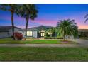 Charming single-story home with a lush green lawn and mature tropical landscaping, creating a welcoming curb appeal at 8540 Caitlin Ct, Hudson, FL 34667