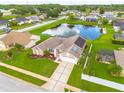 Scenic aerial view of home showcasing the surrounding community, lake, and well-maintained backyard at 8811 Napa Loop, New Port Richey, FL 34653