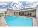 Relaxing outdoor pool area with a screened enclosure and patio space for lounging at 8811 Napa Loop, New Port Richey, FL 34653