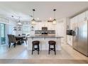 Modern kitchen boasts a large island, stainless steel appliances, granite countertops, and pendant lighting at 8855 Prairie Creek Dr, New Port Richey, FL 34655