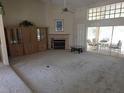Spacious living room featuring neutral carpeting, a fireplace, and sliding glass doors to the outside at 9168 Southern Comfort Ct, Weeki Wachee, FL 34613