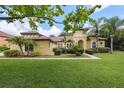 Beautiful Mediterranean-style home with a lush green lawn, meticulously manicured landscaping, and a charming architectural design at 9829 Sorbonne Loop, Seffner, FL 33584