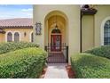 Charming front entrance with red door, brick walkway, manicured hedges, and an elegant number plaque at 9829 Sorbonne Loop, Seffner, FL 33584