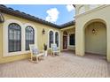 Inviting front porch with rocking chairs, textured brick, and arched windows creates a charming outdoor space at 9829 Sorbonne Loop, Seffner, FL 33584