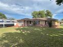 Traditional single story home with a large front yard and RV parked to the side of the home at 10458 Clingman St, Spring Hill, FL 34608