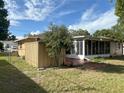 Home's exterior includes a screened in porch with a fenced in backyard and mature trees at 10458 Clingman St, Spring Hill, FL 34608