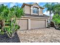 Inviting two-story home with a three-car garage and brick paver driveway at 10925 Oyster Bay Cir, New Port Richey, FL 34654