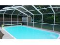 Inviting screened-in pool featuring clear, blue water and a spacious deck area perfect for relaxing at 11810 Oceanside Dr, Port Richey, FL 34668