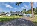 Inviting one-story home boasting a gravel driveway, green lawn, and attractive light blue facade at 2027 Fentress Ct, Spring Hill, FL 34609