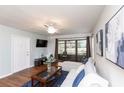 Comfortable living room with ceiling fan, TV, and glass doors leading to the lanai at 3153 Lake Pine Way # A1, Tarpon Springs, FL 34688