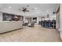 Open-concept living room featuring a modern fireplace, tile floors, and a ceiling fan at 34955 Blanton Rd, Dade City, FL 33523