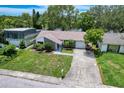 Aerial view of a home with a green lawn, and a long driveway at 3545 Landale Dr, Holiday, FL 34691