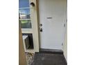 Entrance to the condo unit with the door, exterior light fixture, and window air conditioning unit at 4743 Jasper Dr # 107, New Port Richey, FL 34652
