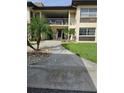 Exterior facade of the condos with palm trees, well-manicured lawn, and numbered address at 4743 Jasper Dr # 107, New Port Richey, FL 34652