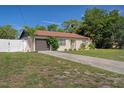 Well-maintained single-story home with a tidy lawn, tidy landscaping, and an attached garage with driveway at 6347 Shadydale Ave, Spring Hill, FL 34609