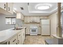 Bright kitchen featuring white cabinets, classic appliances, and durable flooring at 7700 Danube Dr # 7700, Hudson, FL 34667