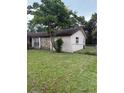 Rear side view of single-story home with a stone facade and chain link fence at 8516 Inwood Dr, Hudson, FL 34667