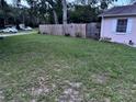 Large grass backyard surrounded by a wooden fence for privacy and greenery at 9536 Mayson St, New Port Richey, FL 34654