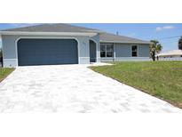 Charming single-Gathering home with a grey finish, concrete tile driveway, and manicured lawn at 310 Day Break Cir, Port Charlotte, FL 33954