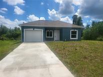 Newly built home with gray siding and two-car garage at 11261 3Rd Ave, Punta Gorda, FL 33955