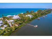 Aerial view of waterfront property with private dock and lush landscaping at 426 N Casey Key Rd, Osprey, FL 34229