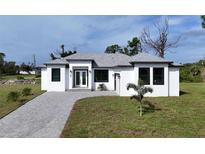 Brand new single-Gathering home with a paved driveway and landscaped lawn at 200 Redwood Rd, Rotonda West, FL 33947