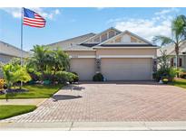 Charming home with a two-car garage, brick driveway, manicured lawn, and an American flag waving proudly at 27855 Arrowhead Cir, Punta Gorda, FL 33982