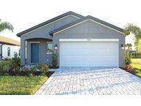 Charming single-story home featuring a gray facade, white garage door, and tidy landscaping at 16821 Sol Preserve Dr, Port Charlotte, FL 33953