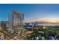 Aerial view of a modern high rise building at sunset by the water at 668 Quay Commons # 504, Sarasota, FL 34236