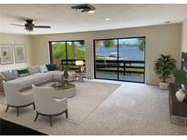 Bright living room with water views and sliding glass doors to balcony at 1210 Casey Key Rd, Nokomis, FL 34275