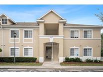 Tan two-story condo building with stairs and landscaping at 9505 Amberdale Ct # 201, Riverview, FL 33578