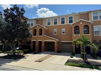 Tan three-story townhome with two-car garage, and landscaping at 8807 White Sage Loop # 1903, Lakewood Ranch, FL 34202