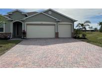 Two-car garage and paver driveway with a neutral-colored exterior at 2275 Hamburg Ln, Punta Gorda, FL 33983