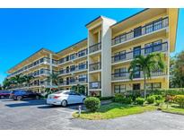 Building exterior showcasing a two-story condo building with ample parking and lush landscaping at 315 30Th W Ave # B305, Bradenton, FL 34205