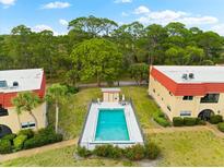 Community pool area with surrounding landscaping and access from condo buildings at 209 Rubens Dr # E, Nokomis, FL 34275