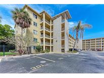 Exterior view of a condo building with ample parking and lush landscaping at 3514 Lake Bayshore Dr # K-108, Bradenton, FL 34205