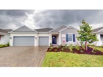 Two-car garage home with gray siding and blue shutters at 1575 Laurel Brook Ln, Port Charlotte, FL 33953